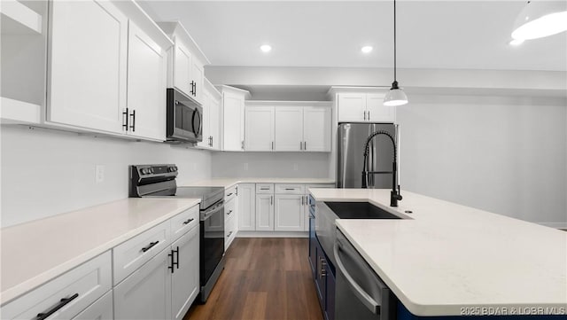 kitchen with appliances with stainless steel finishes, pendant lighting, white cabinets, light stone countertops, and dark wood-type flooring