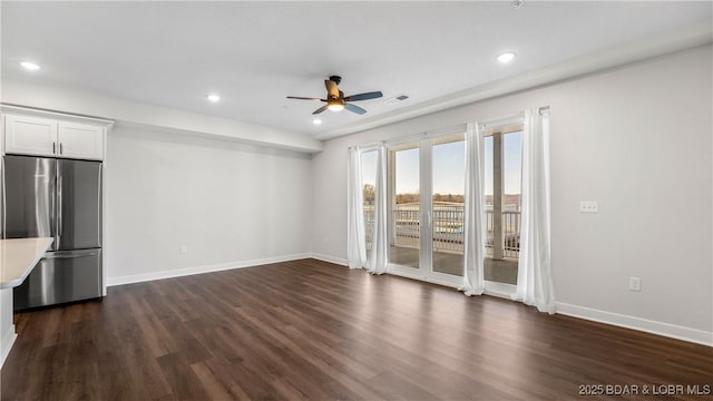 unfurnished living room with dark hardwood / wood-style flooring and ceiling fan