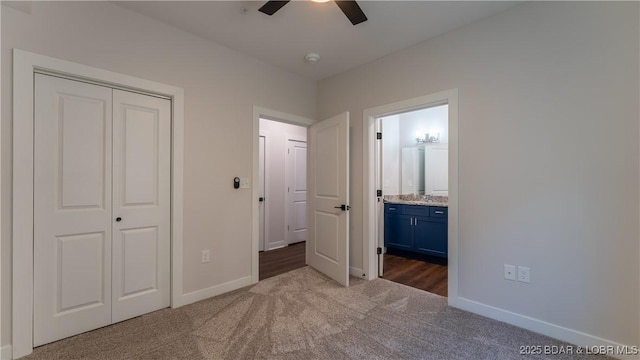 unfurnished bedroom with ceiling fan, a closet, connected bathroom, and carpet