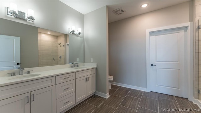 bathroom with vanity, toilet, and a shower with shower door