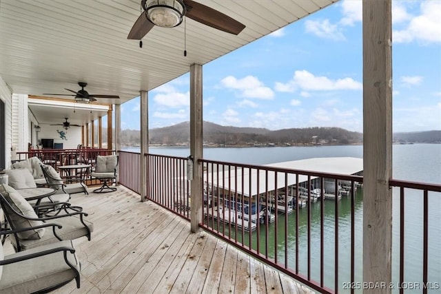 deck featuring ceiling fan and a water view