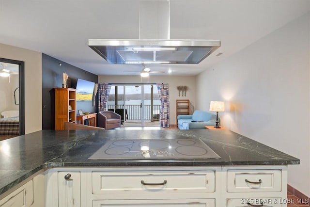 kitchen with range hood, white cabinetry, dark stone counters, black electric stovetop, and ceiling fan