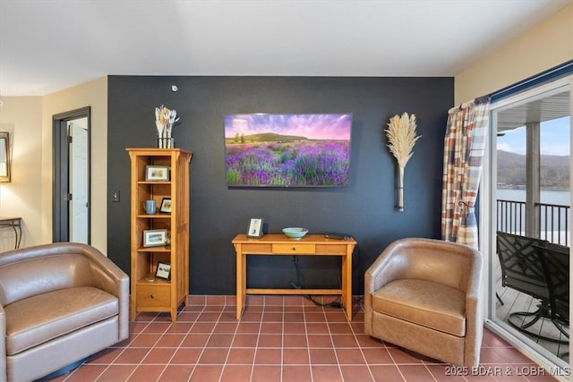 living area with a water view and tile patterned floors