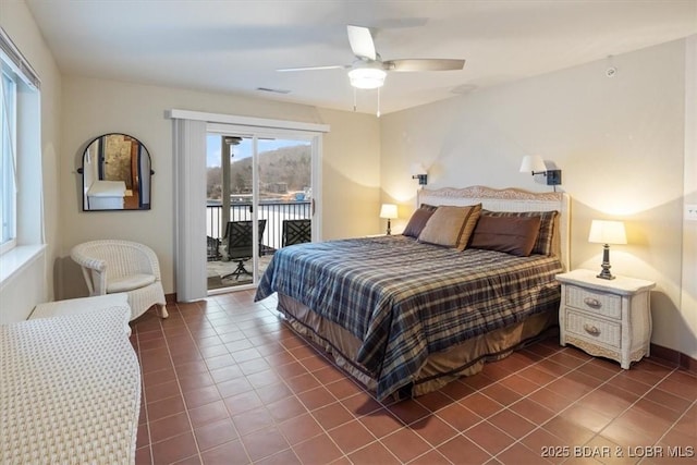 bedroom featuring ceiling fan, dark tile patterned floors, and access to outside