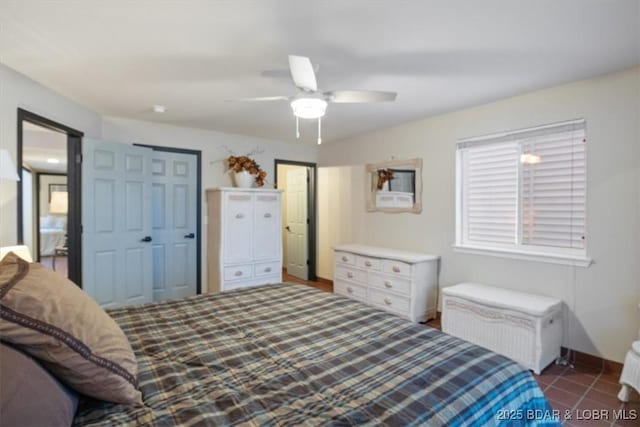 bedroom with ceiling fan and dark tile patterned floors