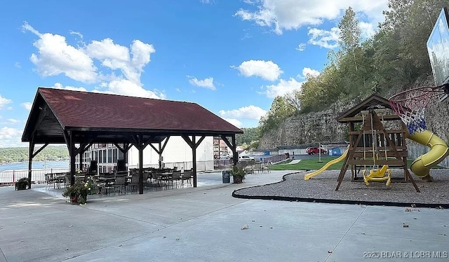 view of play area featuring a patio area and a water view