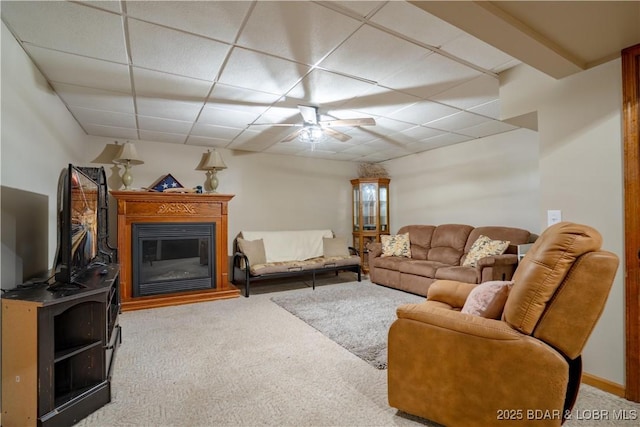 living room with a paneled ceiling and carpet