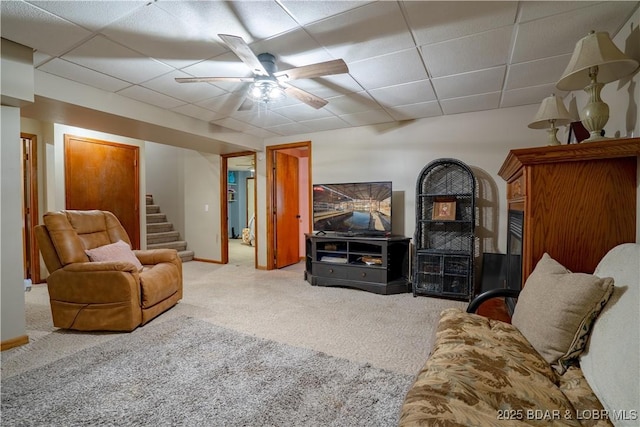 living room with carpet floors, ceiling fan, and a paneled ceiling