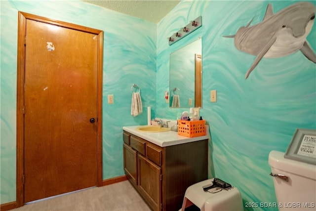 bathroom featuring vanity, toilet, and a textured ceiling