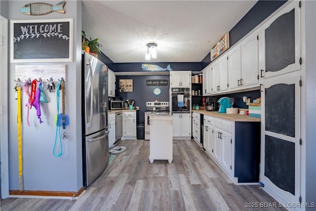 kitchen featuring white cabinetry, appliances with stainless steel finishes, and light wood-type flooring