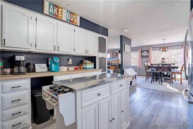 kitchen with pendant lighting, light wood-type flooring, and white cabinets