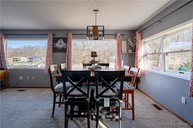 carpeted dining room with a textured ceiling