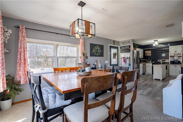 dining space with a chandelier and a textured ceiling