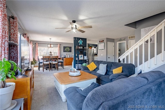 living room featuring ceiling fan, carpet flooring, and a textured ceiling