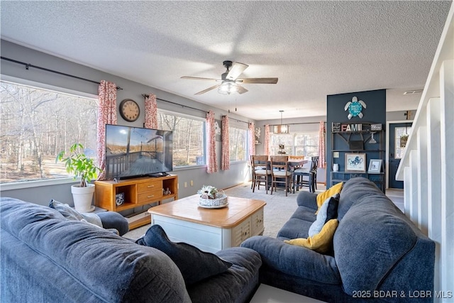 living room featuring a textured ceiling, carpet floors, and ceiling fan