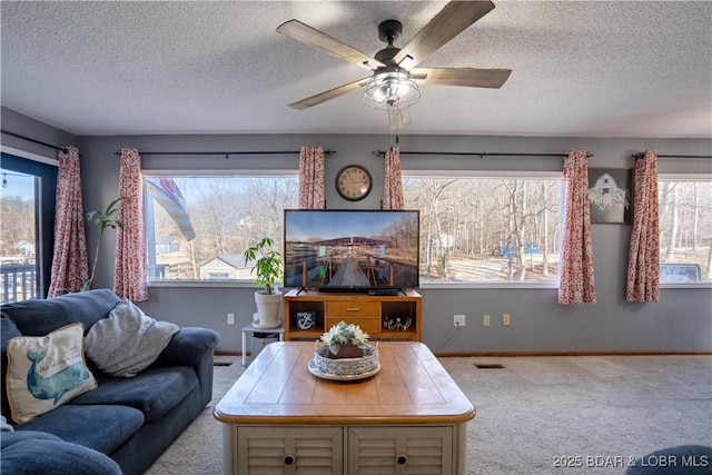 carpeted living room with ceiling fan and a textured ceiling