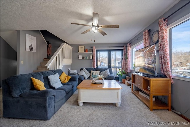 carpeted living room with ceiling fan and a textured ceiling