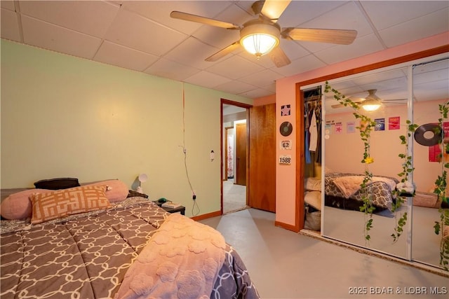 bedroom with ceiling fan, a paneled ceiling, and a closet