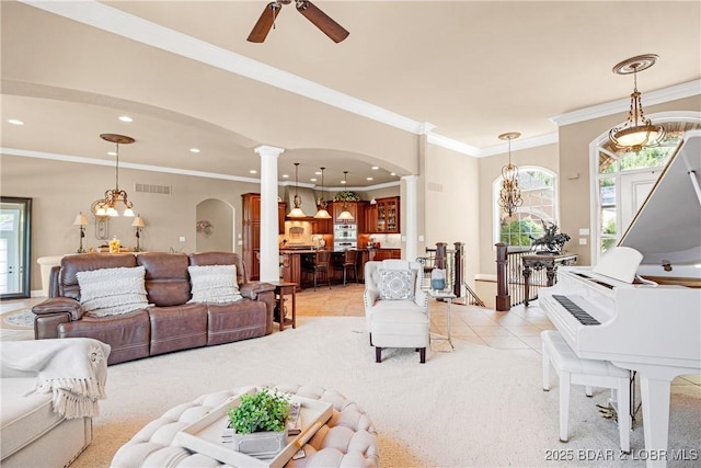 tiled living room featuring crown molding, ceiling fan, and ornate columns