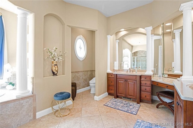 bathroom with decorative columns, tile patterned flooring, and toilet