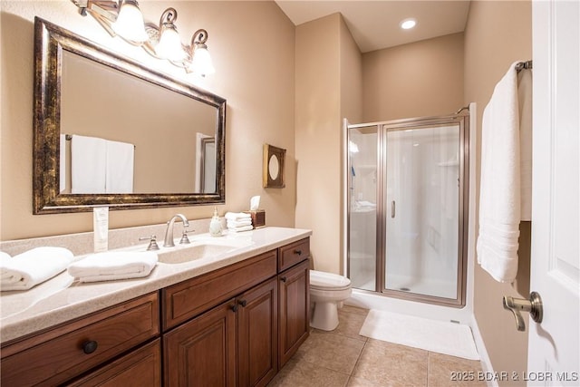 bathroom featuring tile patterned floors, toilet, a shower with door, and vanity