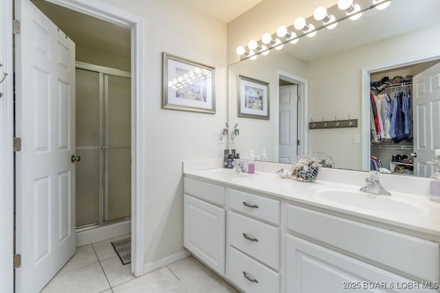 bathroom featuring tile patterned flooring, vanity, and a shower with door