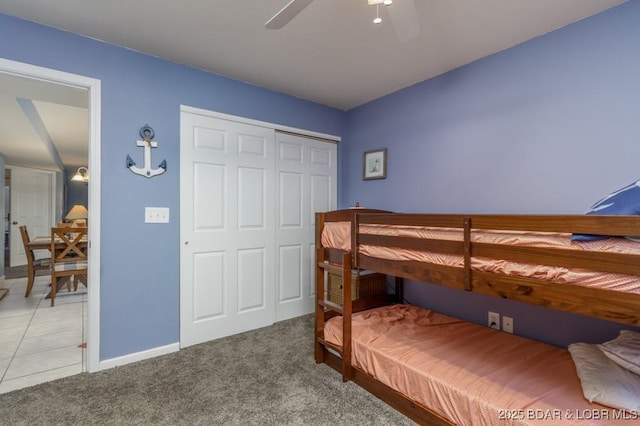 carpeted bedroom with ceiling fan and a closet