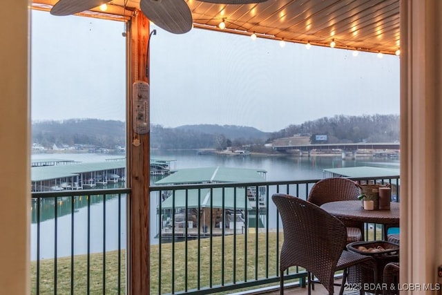 balcony with a water view and ceiling fan