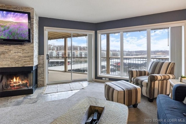 carpeted living room featuring a water view and a fireplace