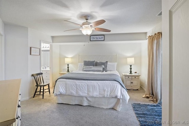 bedroom featuring ceiling fan, light colored carpet, and a textured ceiling