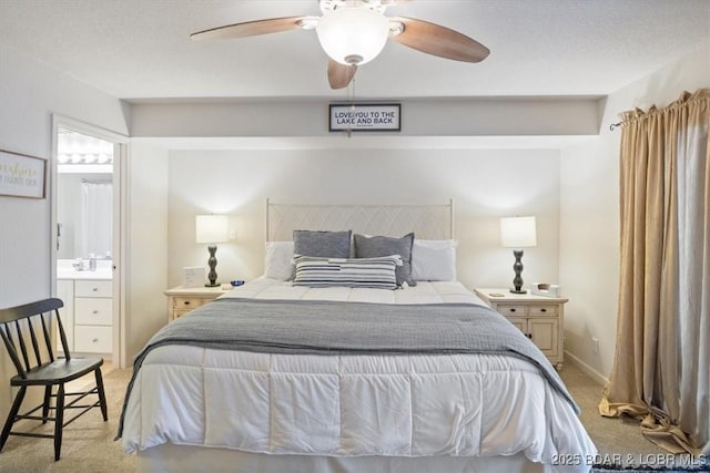 carpeted bedroom with ensuite bathroom, a textured ceiling, and ceiling fan