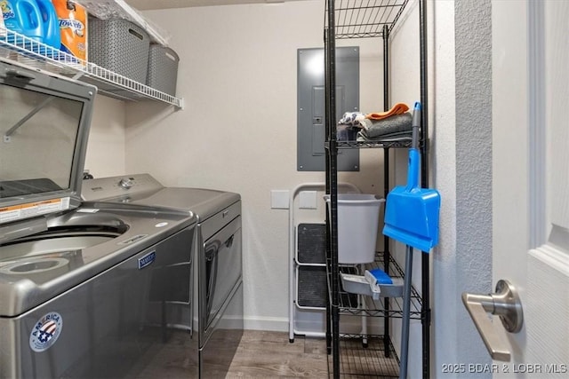 laundry room featuring hardwood / wood-style flooring, electric panel, and separate washer and dryer