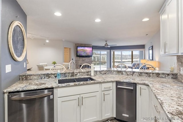 kitchen with dishwasher, sink, white cabinets, and kitchen peninsula