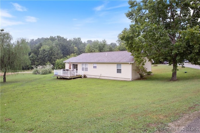 back of property featuring a lawn and a deck