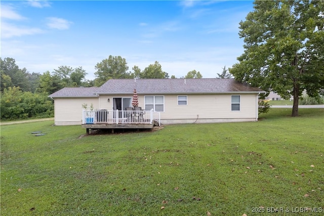 rear view of house with a wooden deck and a yard