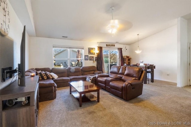 carpeted living room featuring ceiling fan and vaulted ceiling