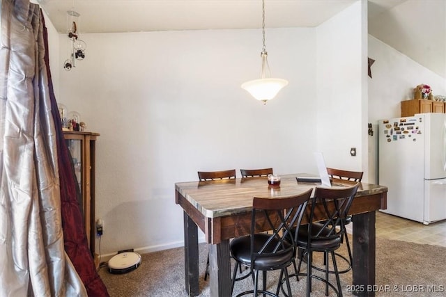 carpeted dining room featuring lofted ceiling