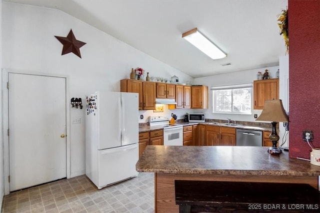 kitchen featuring vaulted ceiling, sink, white appliances, and kitchen peninsula