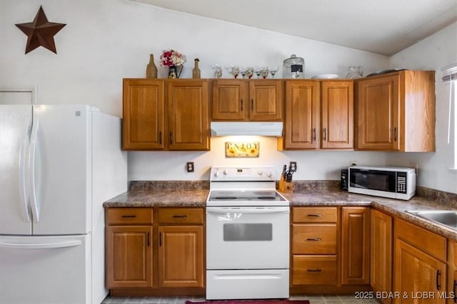 kitchen featuring vaulted ceiling, sink, and white appliances