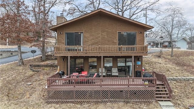 rear view of house featuring a wooden deck