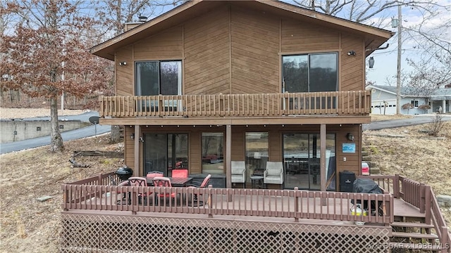 rear view of property featuring a wooden deck