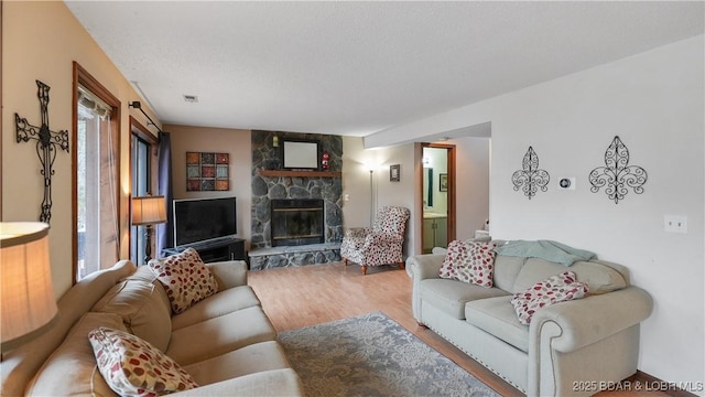 living room featuring hardwood / wood-style floors, a fireplace, and a textured ceiling