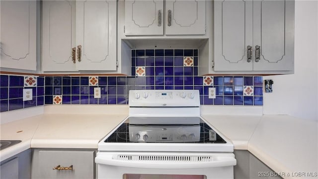 kitchen featuring backsplash, white electric range, and gray cabinetry