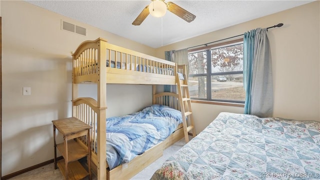 bedroom featuring ceiling fan, light carpet, and a textured ceiling