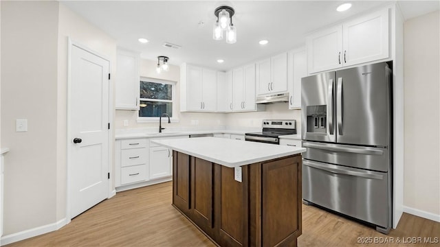 kitchen with white cabinetry, light hardwood / wood-style floors, stainless steel appliances, and a center island