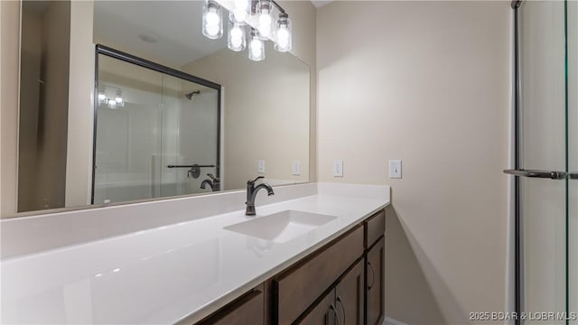 bathroom featuring a chandelier, vanity, and a shower with shower door