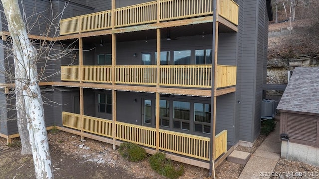 back of house featuring cooling unit, ceiling fan, and a balcony