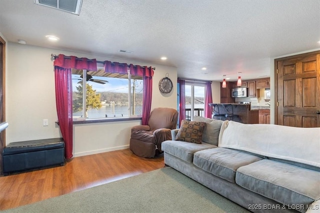 living room with a textured ceiling and light wood-type flooring