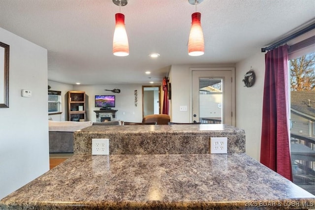 29556 Hunter Rd, Gravois Mills, MO 63069 - kitchen with a kitchen island, dark countertops, a lit fireplace, hanging light fixtures, and recessed lighting