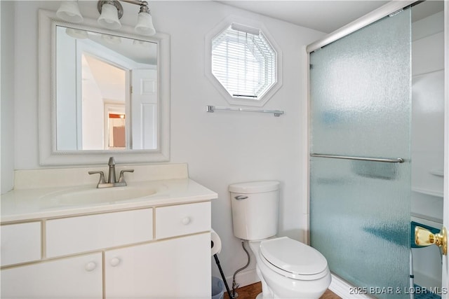 bathroom with walk in shower, vanity, and toilet